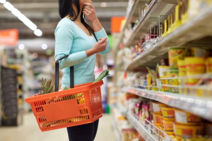 donna al supermercato con il cestello attaccato al braccio
