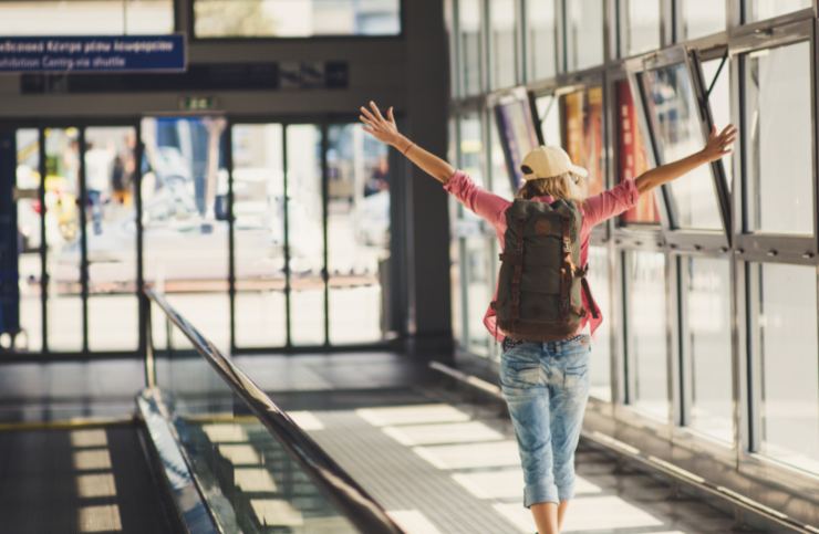 donna in aeroporto con lo zaino sulle spalle