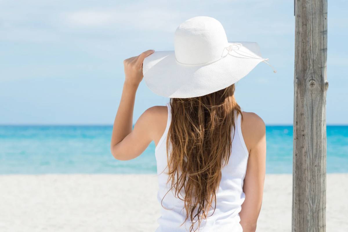 Donna al mare con cappello bianco