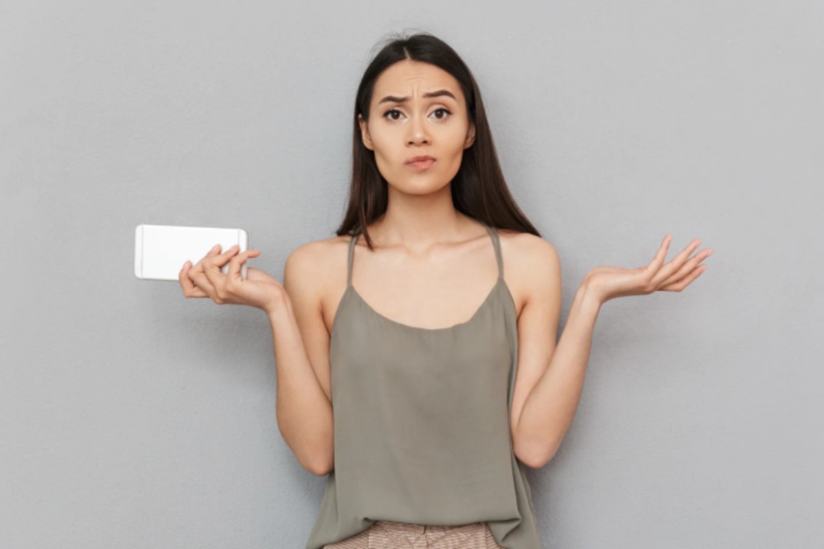 donna con espressione confusa con il cellulare in mano