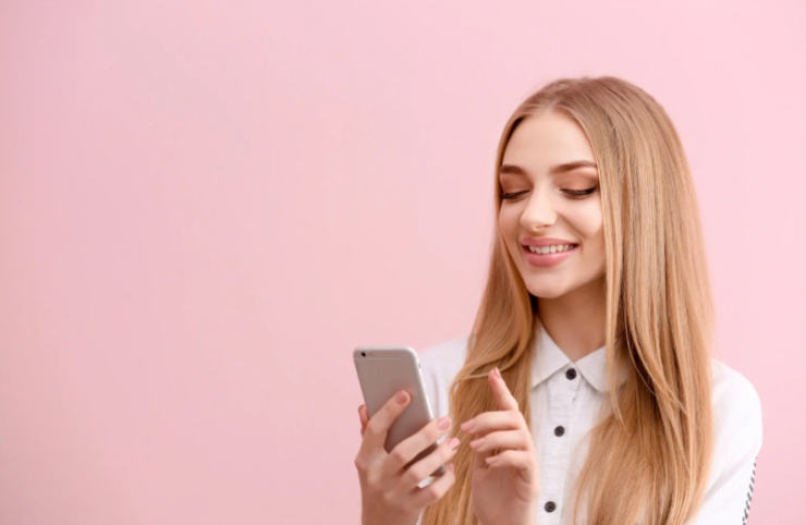 donna che sorride con il cellulare in mano