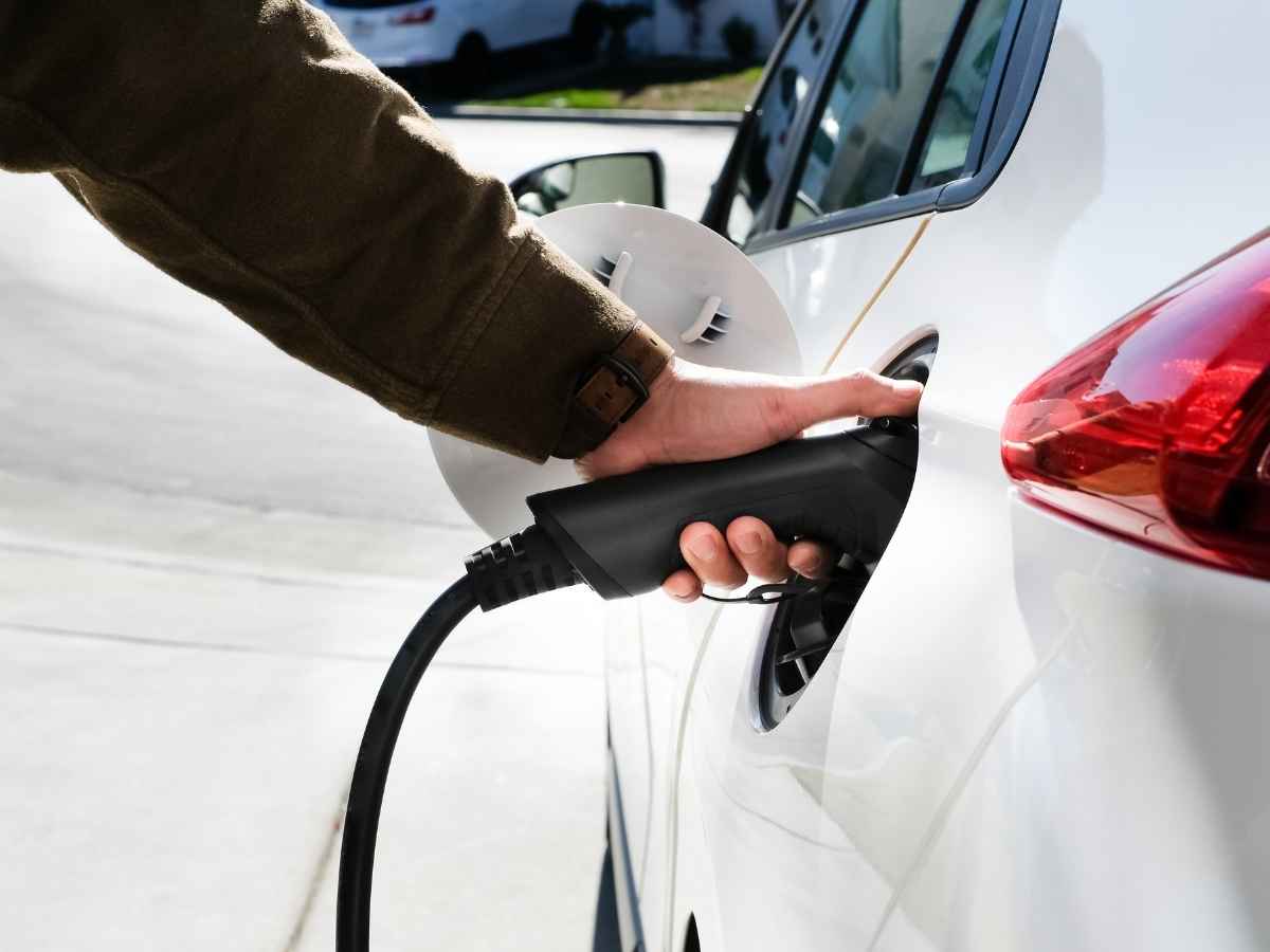 Uomo che ricarica auto elettrica