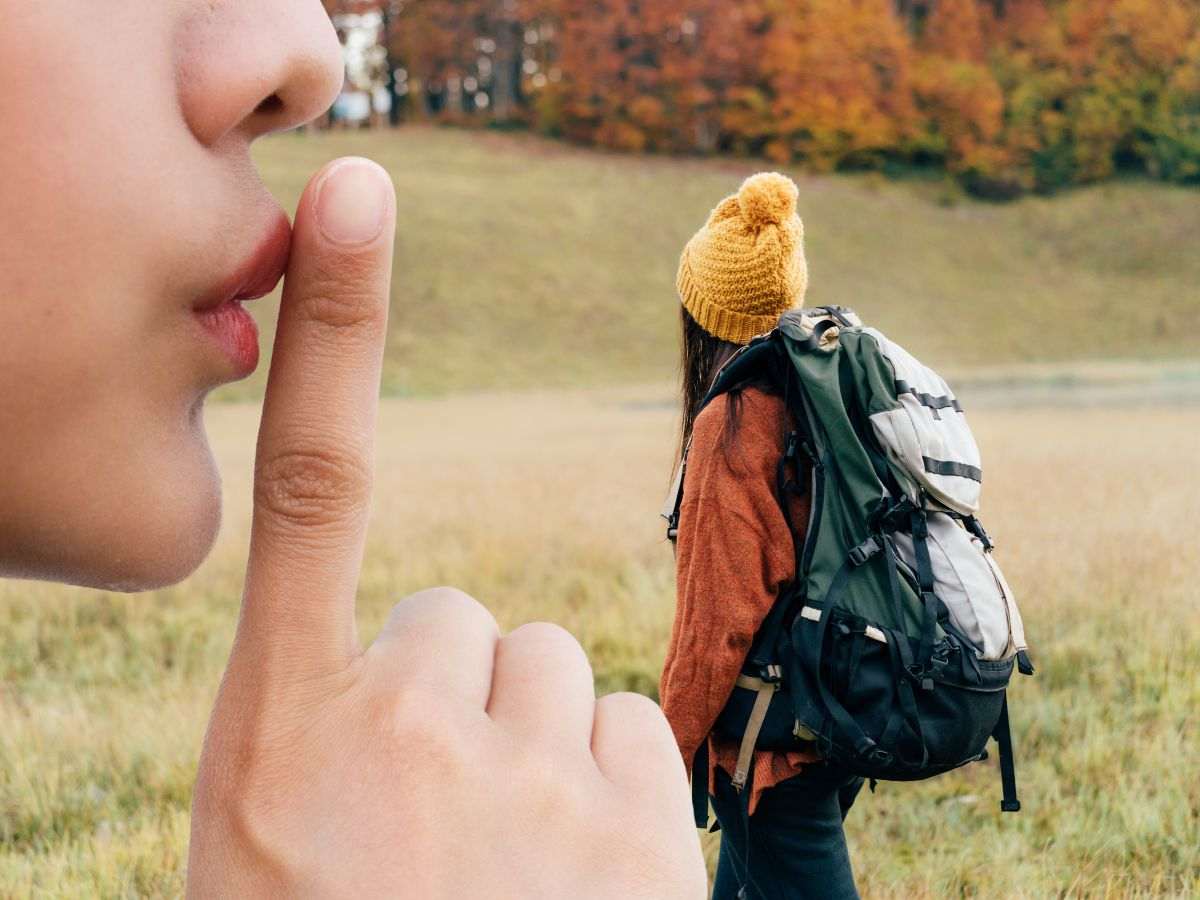 sfondo donna che fa trekking in paesaggio autunnale e donna che fa segno di silenzio