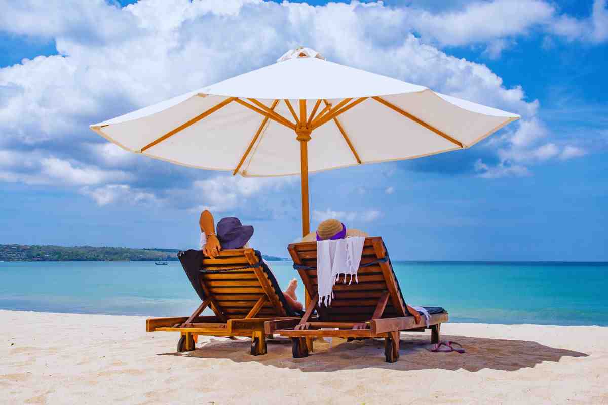 Persone sul lettino e sotto l'ombrellone in spiaggia