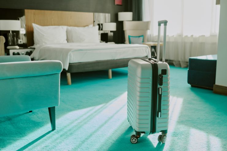 Valigia celeste nel centro della stanza d'hotel
