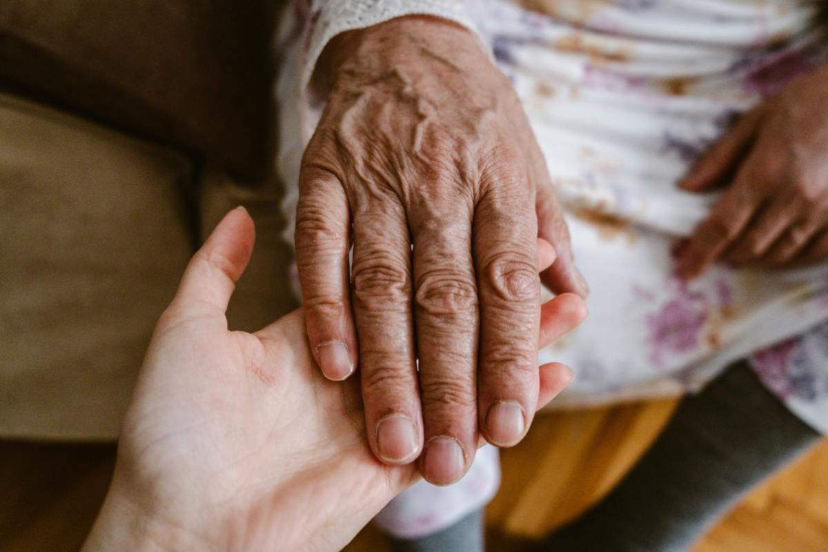 mano di un'anziana sopra a quella della nipote