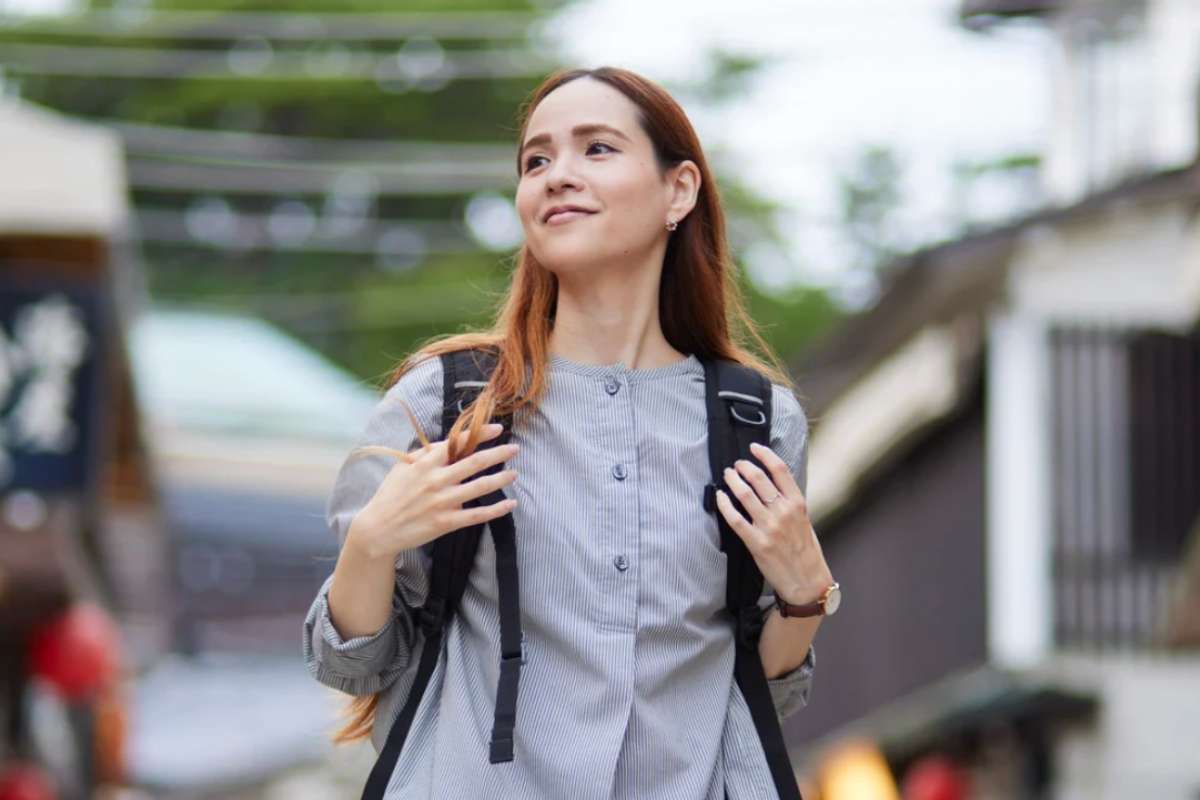 Ragazza che sorride con zaino sulle spalle