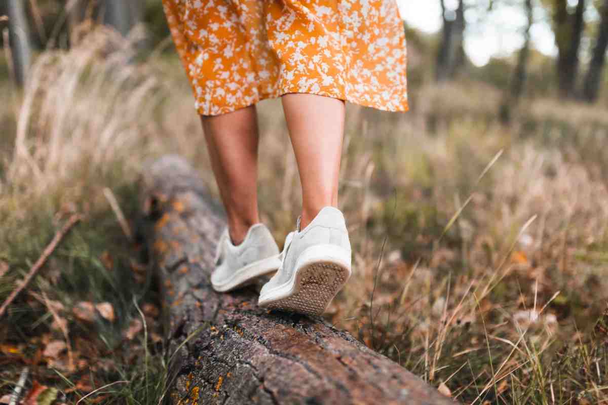 Donna che cammina su un tronco caduto