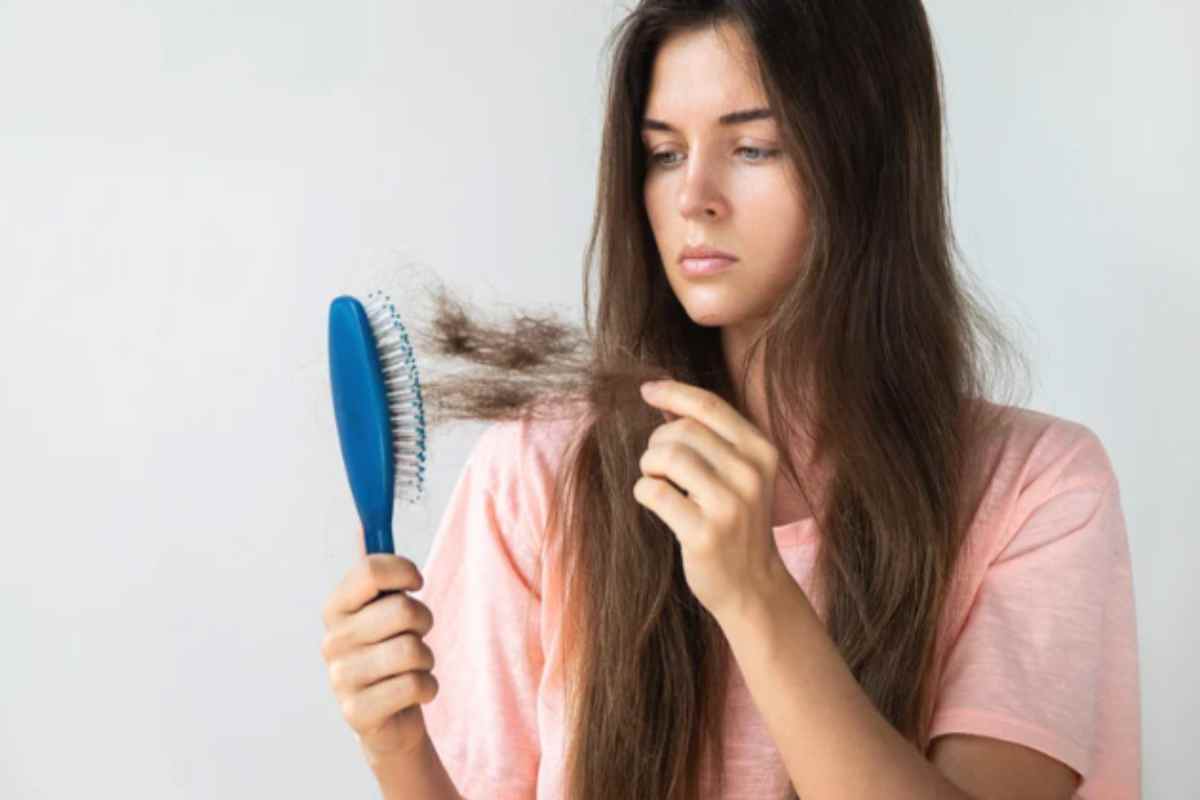 Ragazza preoccupata dai capelli rimasti nella spazzola