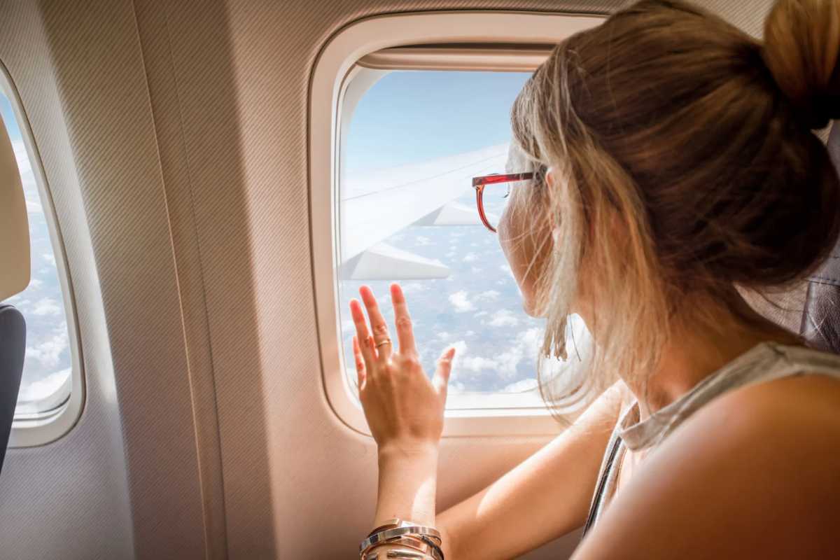 Donna che guarda fuori dal finestrino in aereo