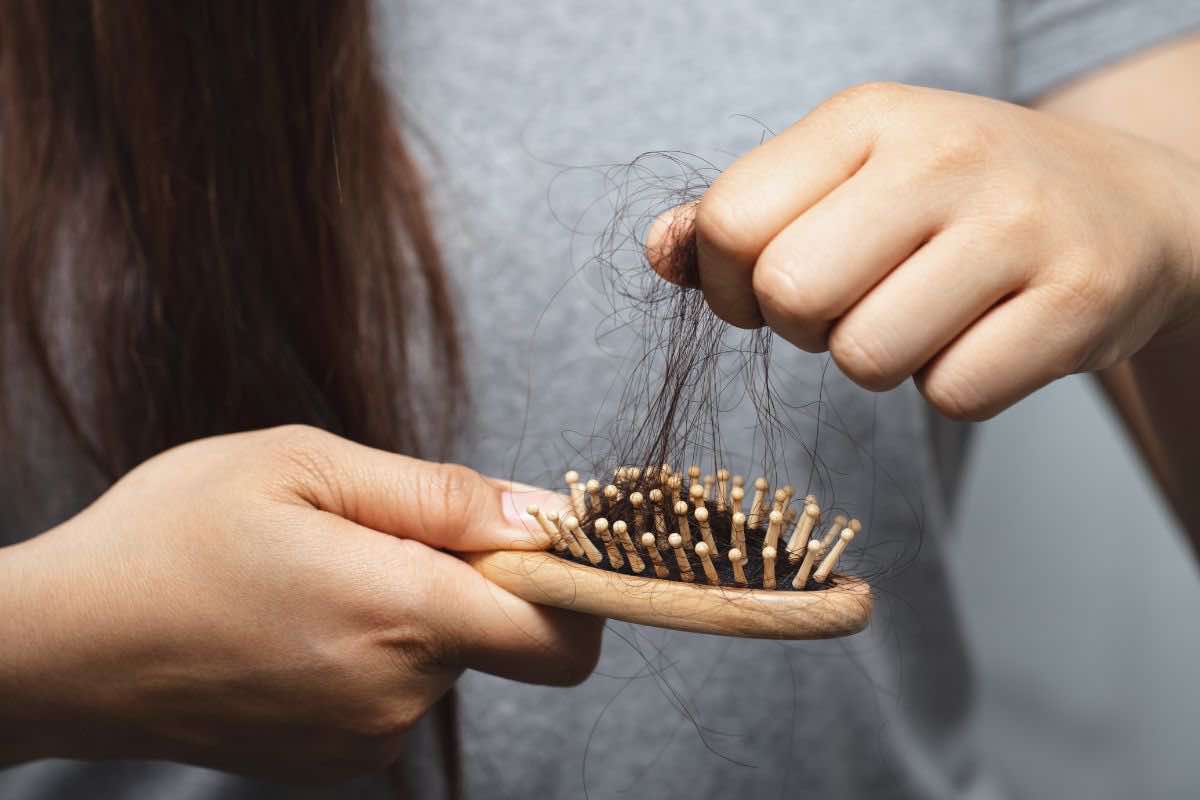 Donna che pulisce spazzola da capelli