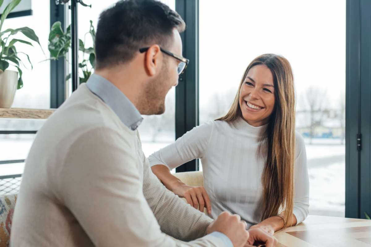 Una donna che sorride e un uomo di spalle