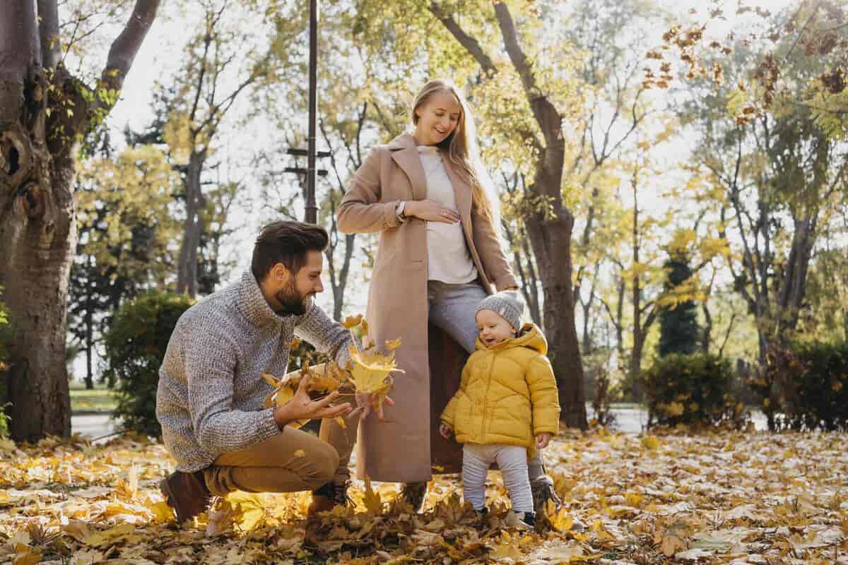 Genitori con bambini piccoli al parco in autunno