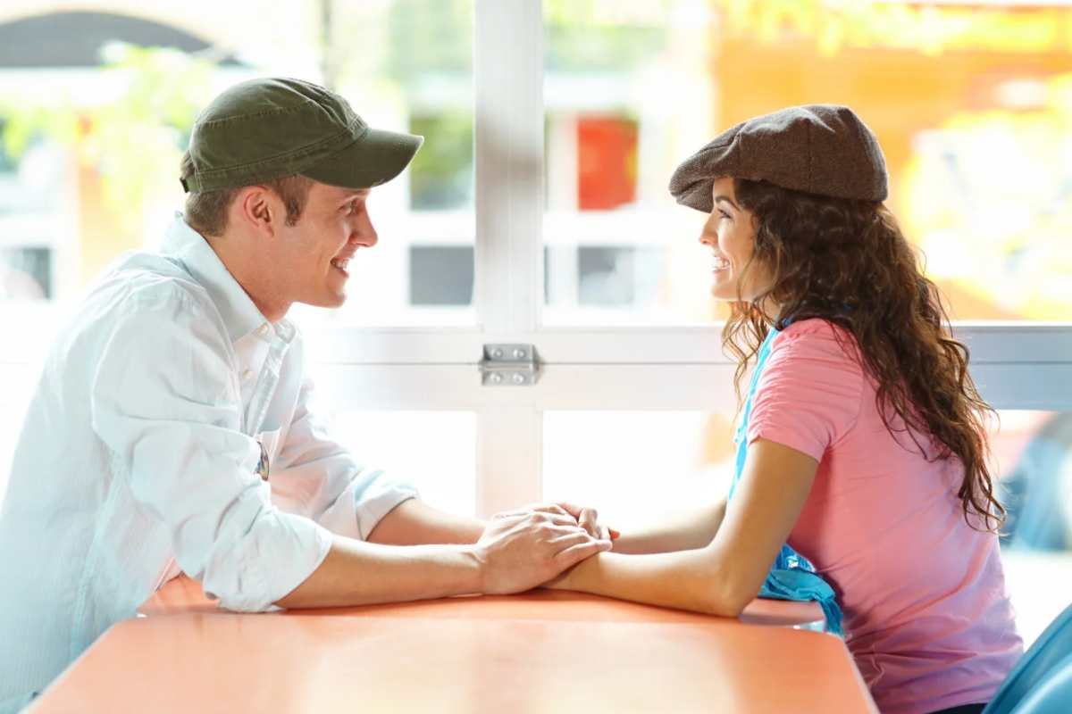 Un uomo e una donna seduti che si stringono le mani