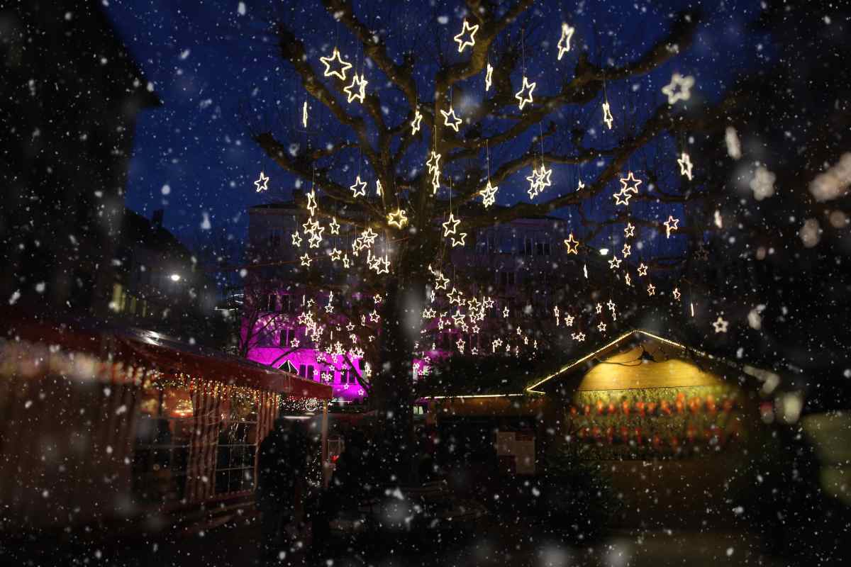 Mercatini di Natale a Zurigo: piazza con luci a forma di stelle e neve che scende