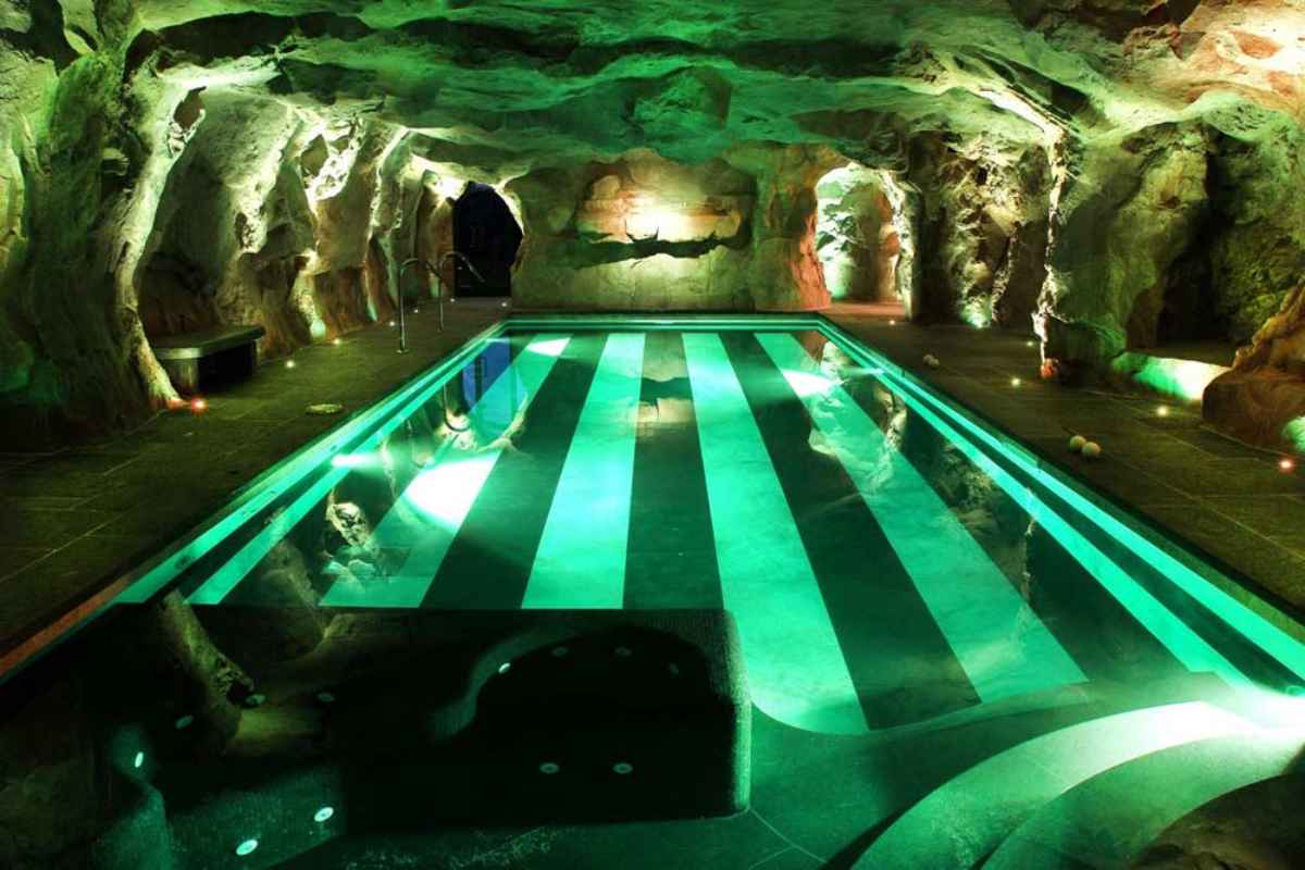 Piscina illuminata di verde nella grotta Castello di Guarene