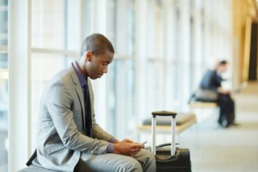 Uomo che guarda il telefono in aeroporto