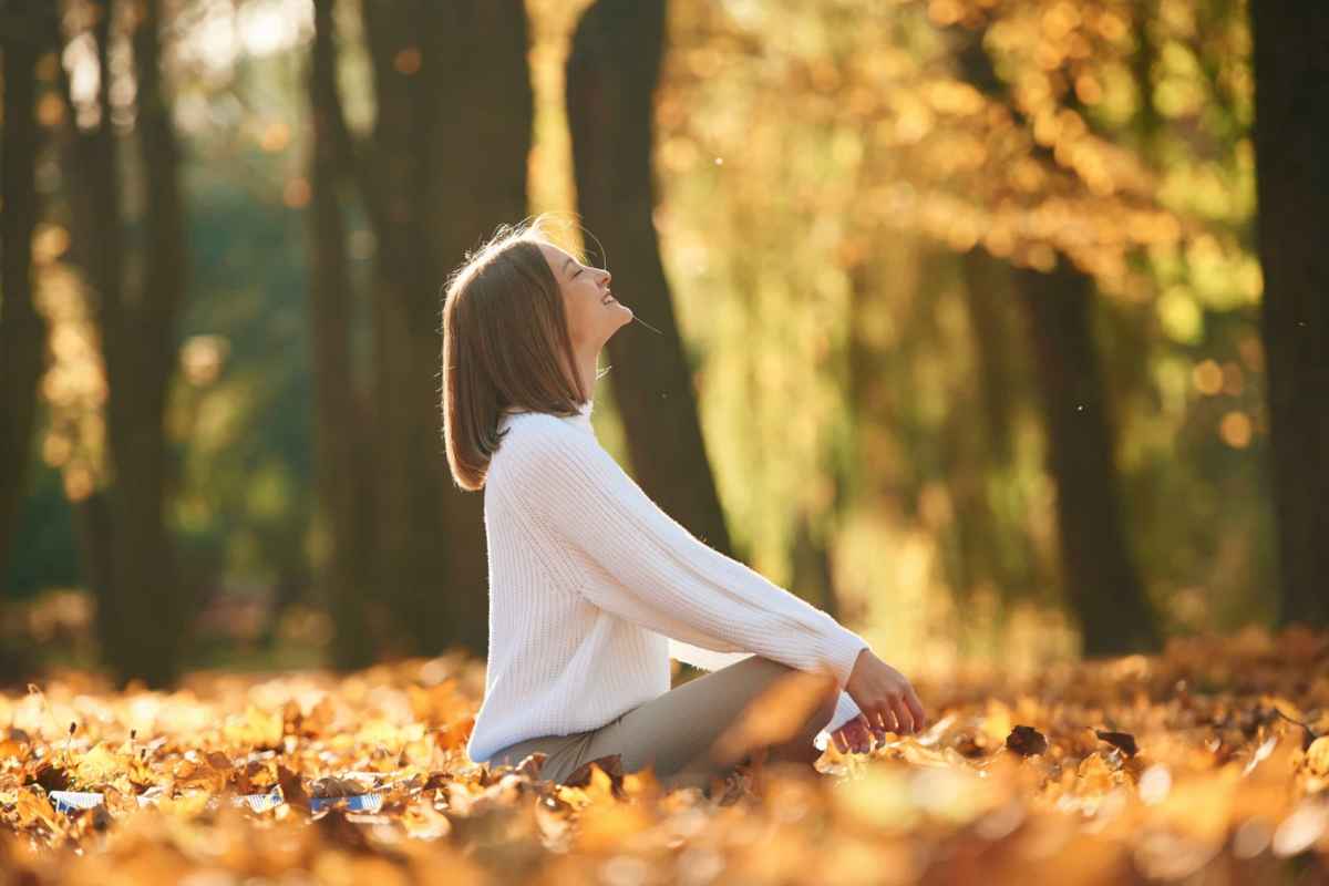 Donna seduta tra le foglie cadute