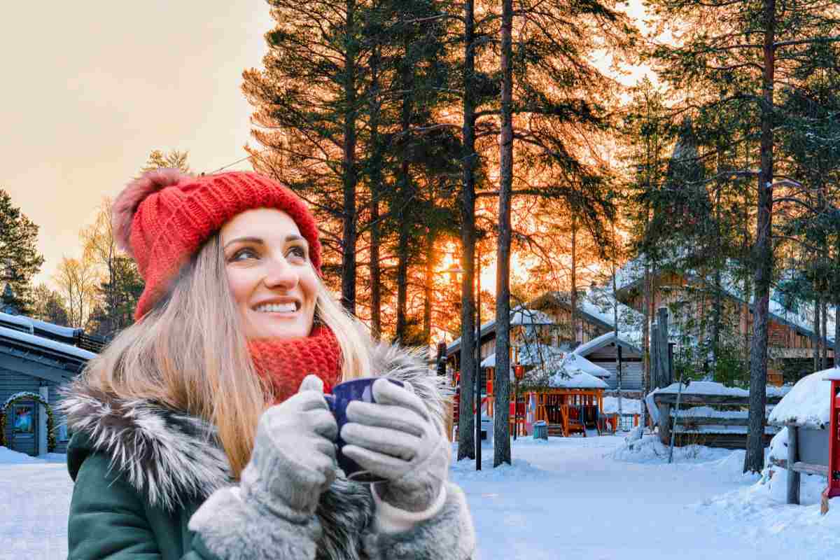 donna che beve da una tazza in uno scenario innevato