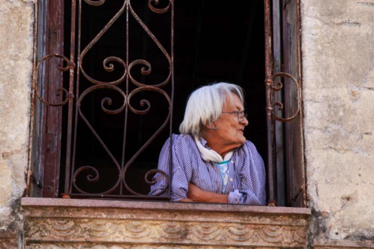signora anziana affacciata dalla finestra