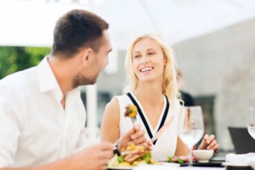 uomo e donna che mangiano e sorridono