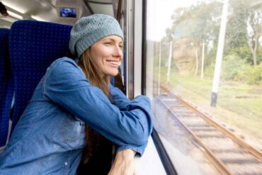 Donna sorridente che guarda fuori dal finestrino del treno
