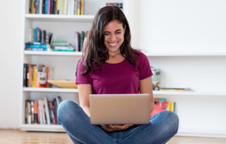 donna seduta sul pavimento con il computer sulle ginocchia