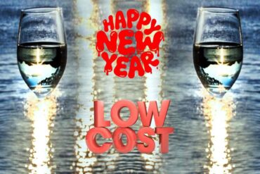 bicchieri con champagne, scritta low cost e happy new year