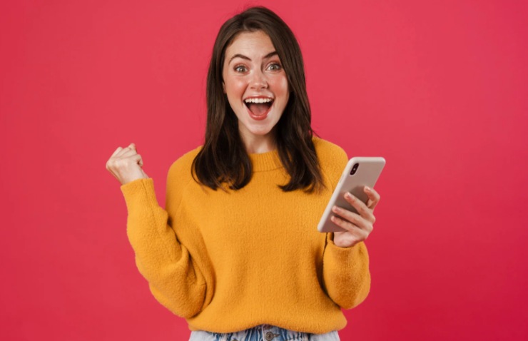 donna felice che esulta con il cellulare in mano