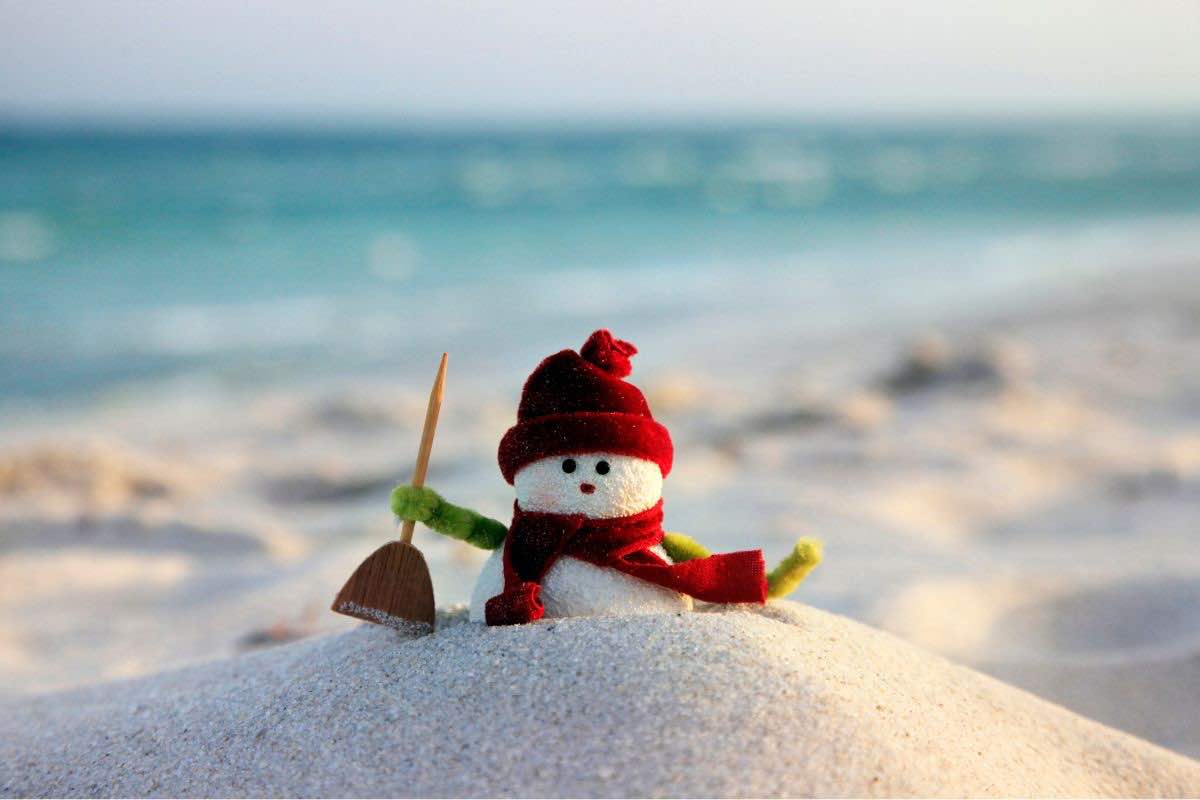 Pupazzo di neve fatto con la sabbia in spiaggia