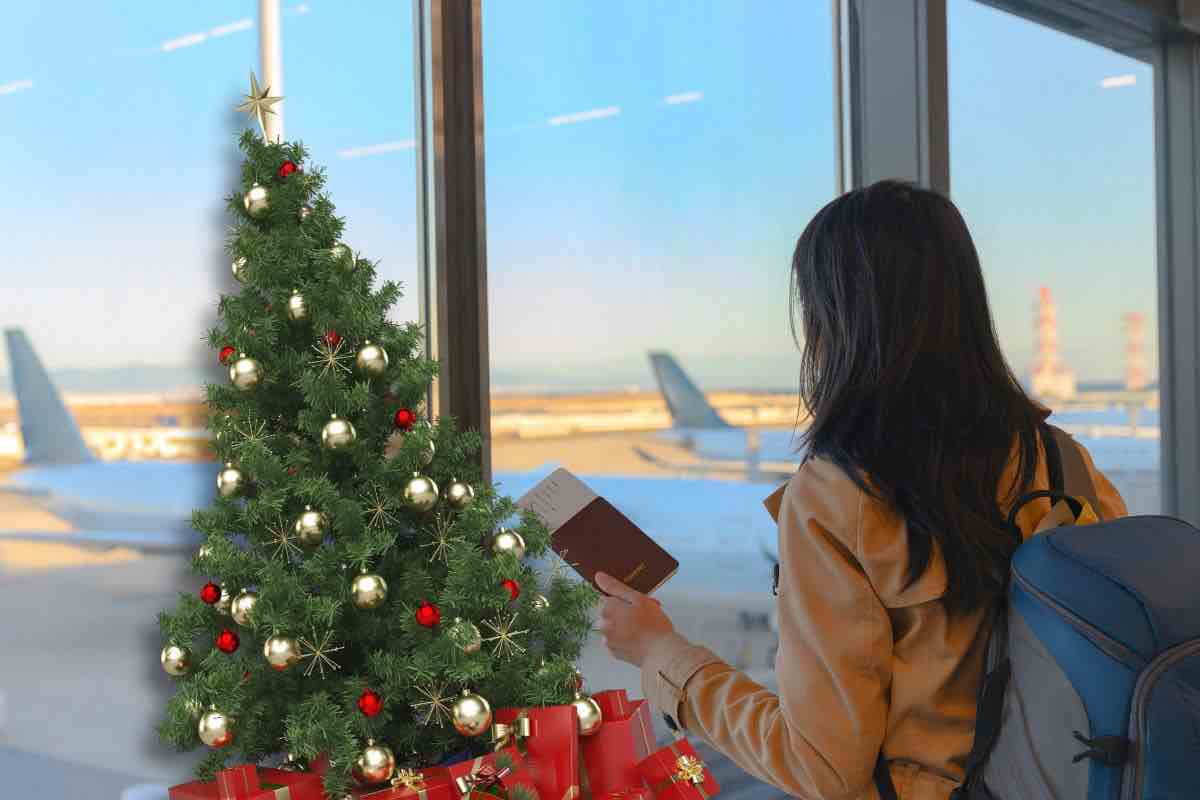 Donna in aeroporto con passaporto in mano, aerei sullo sfondo e albero di Natale