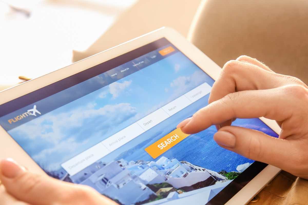Persona che cerca voli su sito web tablet