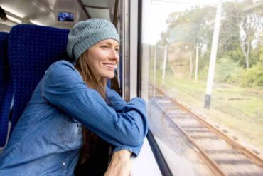 donna in treno che guarda fuori dal finestrino