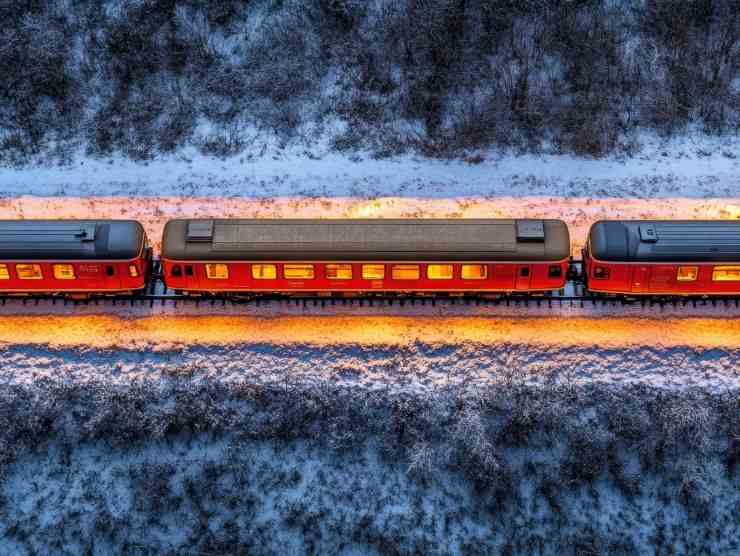 treno che viaggia di notte in un paesaggio innevato