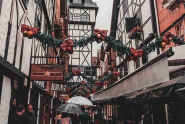 Uomo che cammina in un vicolo natalizio