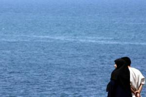 An Algerian couple looks at the sea at B