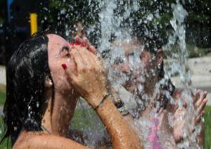 Spanish tourists cool off in a fountain