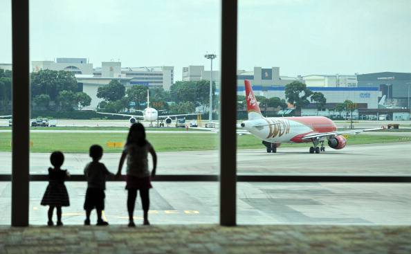 Children watch as an AirAsia plane leave